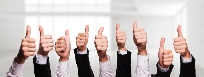 Grupa ludzi w garniturach pokazująca kciuki w górę